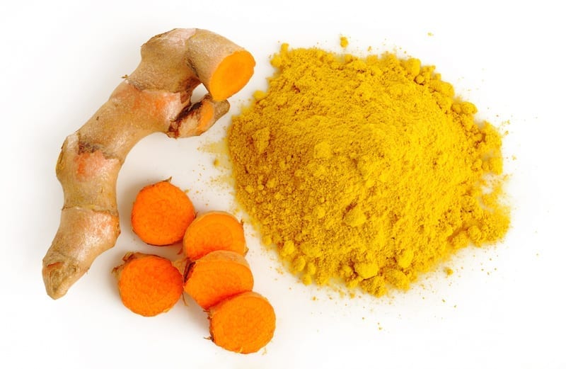 A white plate topped with carrots and turmeric.